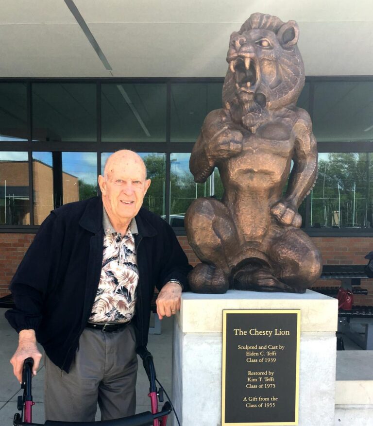 Hospice patient standing next to the Lawrence Lion