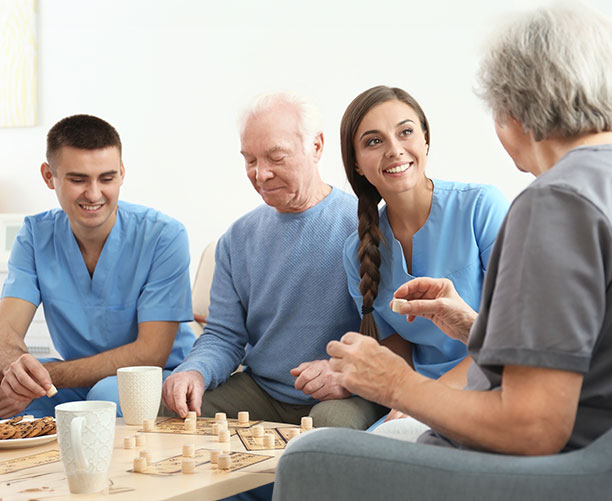 Senior People Playing Bingo With Their Caregivers
